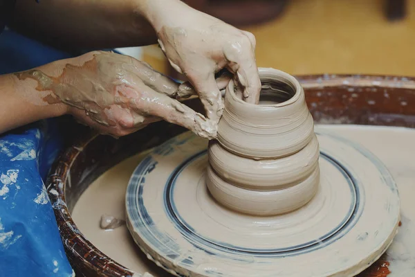 Mãos de mulher na roda de cerâmica. Artista artista formas pote — Fotografia de Stock