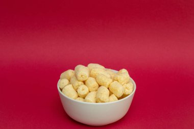 Beyaz kasede pudra şekerli gevrek mısır çubukları.