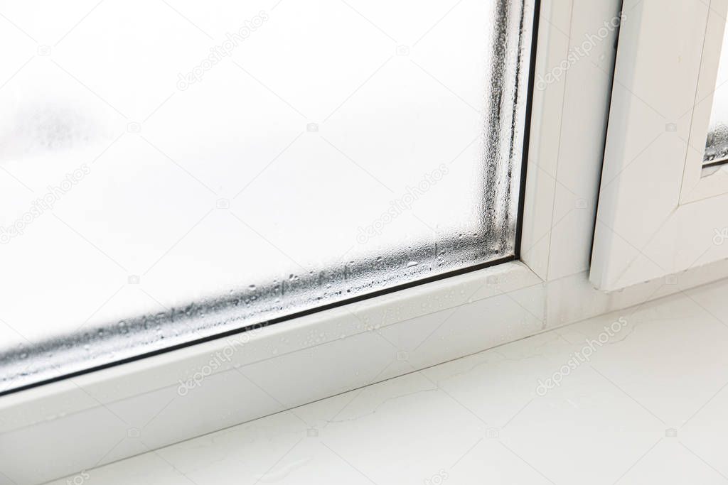 Plastic window with damp and water condensation on glass