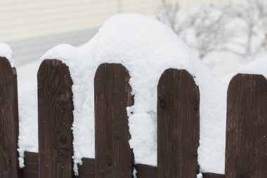 Beyaz karlı arka planda ahşap çit