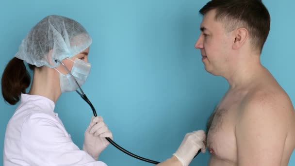Mujer Doctora Máscara Escuchando Respirar Hombre Con Fonendoscopio — Vídeo de stock