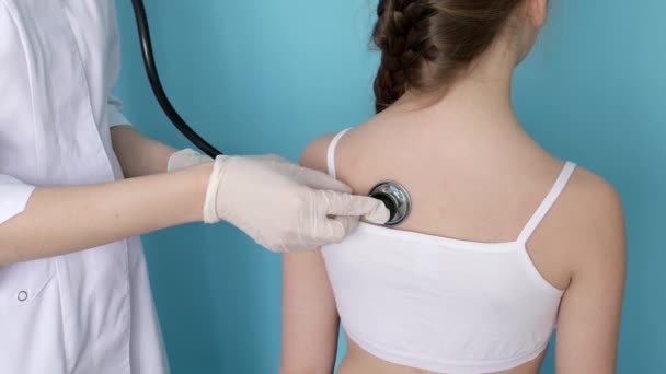 戴口罩的女医生用留声机倾听小女孩的呼吸 — 图库视频影像