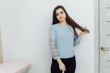 Genç bir kadın güzellik salonunda dudaklarından sonra poz veriyor.