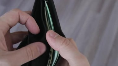 Elinde dolar ve euro banknotlarıyla siyah deri cüzdan tutan bir adamın yakın çekimi.