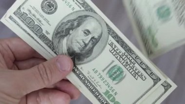 Adam 100 dolarlık banknotları sayıyor. Erkek eli kapalı para saymak