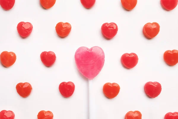 Hari Valentine Pink bentuk lolipop dengan permen merah kecil dalam pola lucu pada latar belakang kertas putih kosong. Konsep Cinta. Gaya hipster warna-warni. Knolling top view . — Stok Foto