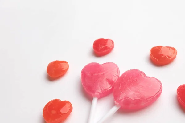 Rózsaszín Valentin nap szív alakú nyalóka a kis piros cukorka aranyos minta-üres fehér papír alapon. Szeretet fogalma. színes hippi stílus. Knolling felülnézet. — Stock Fotó