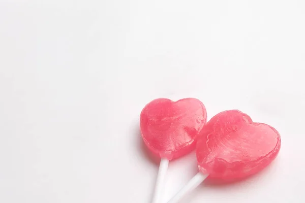 Dos rosa de San Valentín corazón forma caramelo piruleta sobre fondo blanco vacío. Concepto de amor. Minimalismo estilo hipster colorido . — Foto de Stock