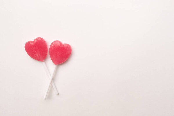 две конфеты в форме сердечка на пустом белом бумажном фоне. Концепция любви. Ноллинг вид сверху. Минимализм красочный хипстерский стиль
.