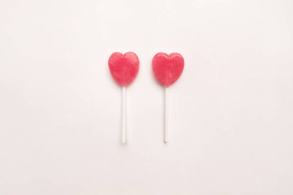 две конфеты в форме сердечка на пустом белом бумажном фоне. Концепция любви. Ноллинг вид сверху. Минимализм красочный хипстерский стиль
.