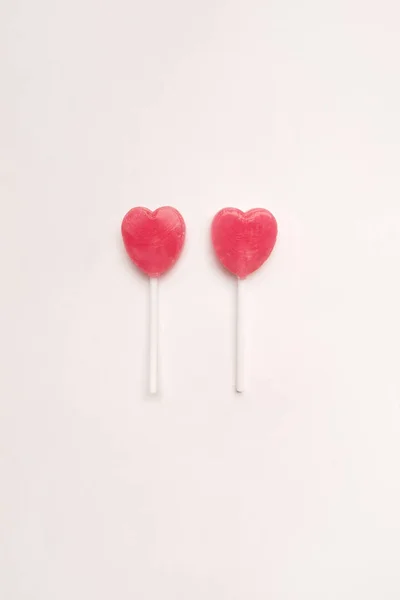 Zwei rosa Valentine Tag Herz Form Lutscher Süßigkeit auf leere weiße Papierhintergrund. Liebe-Konzept. Knolling Draufsicht. Bunte Hipster Minimalismusstil. — Stockfoto