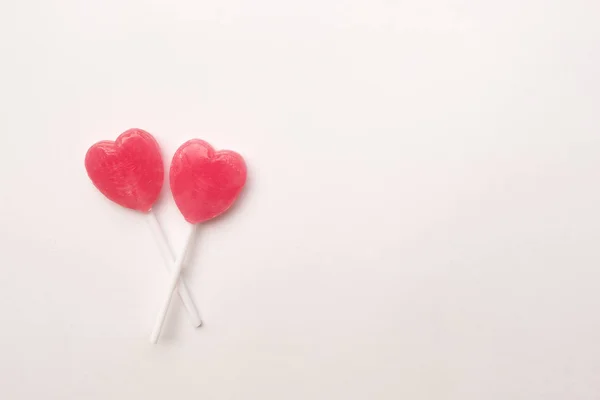 Twee roze Valentine's dag hart vorm lollipop candy op achtergrond van leeg Witboek. Concept van de liefde. Bovenaanzicht van de knolling. Minimalisme kleurrijke hipster stijl. Rechtenvrije Stockfoto's