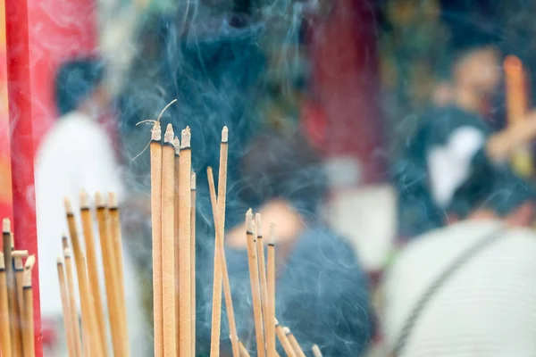 Incense joss stick burning slowly with fragrant smell smoke. People praying on Chinese Buddhist temple on Chinese new year, Luna new year. Stock Image