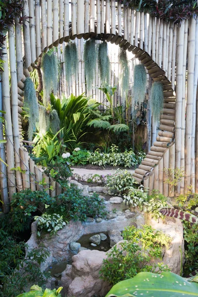 Hermoso estilo tropical de asia con idea de jardín de color verde con decoración de pared de bambú círculo y pequeño lago . — Foto de Stock
