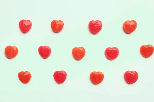 Hari Valentine merah membentuk pola permen pada latar belakang warna kertas pastel hijau. Konsep Cinta. Gaya hipster warna-warni. tampilan atas . — Stok Foto
