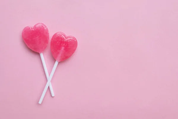 Corazón de San Valentín rosa único caramelo en forma de corazón sobre fondo de papel rosa pastel vacío. Concepto de amor. Vista superior. Minimalismo estilo hipster colorido . —  Fotos de Stock