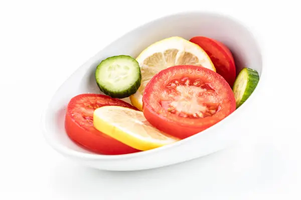 Dairesel sarı limon kırmızı domates ve cuc eğimli beyaz kase