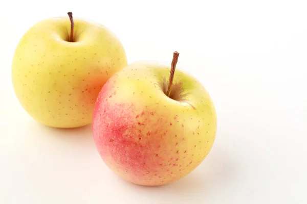 Два жовтих і рожевих яблука — стокове фото