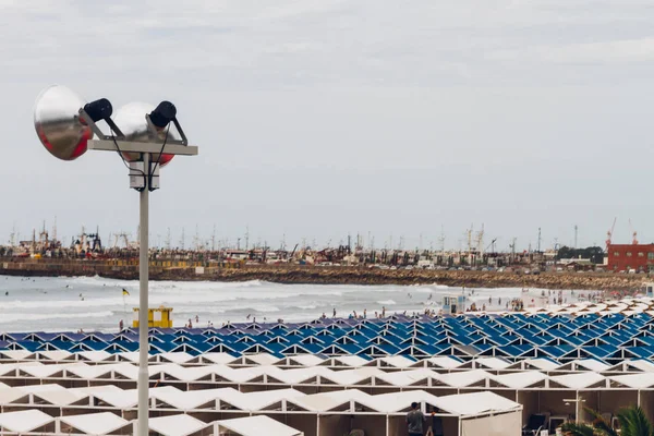 Tents in a seaside resort with reflectors and port on a beach in Mar del Plata, Argentina