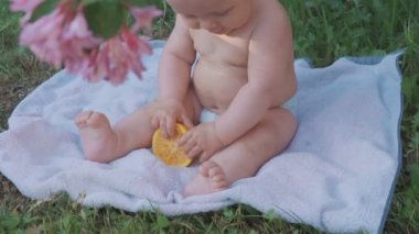 Doğada bir portakal yemek mutlu bebek .