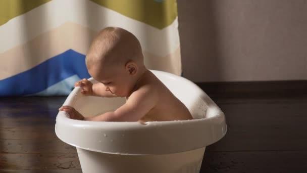 Новонароджена дитина вкрита краплями води крупним планом грає і посміхається в лазні — стокове відео