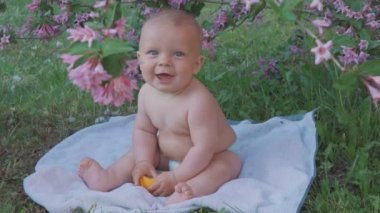 Doğada bir portakal yemek mutlu bebek .