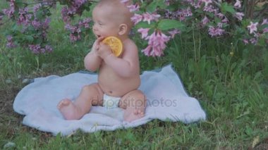 Doğada bir portakal yemek mutlu bebek .