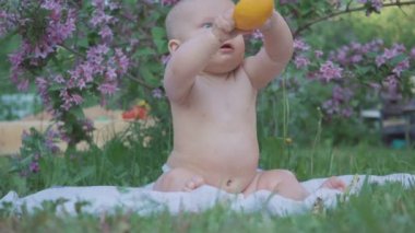 Doğada bir portakal yemek mutlu bebek .