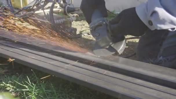 Grinding with a hand-grinder in a private garden. Handmade fence — Stock Video