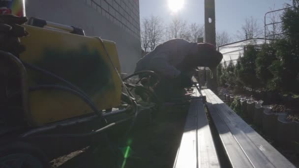 Svetsare av metall svetsning i en privat trädgård. Handgjorda staket — Stockvideo