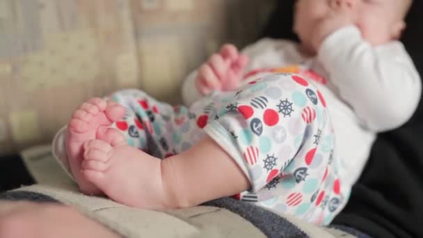 Bébé garçon heureux couché sur les genoux pères — Video