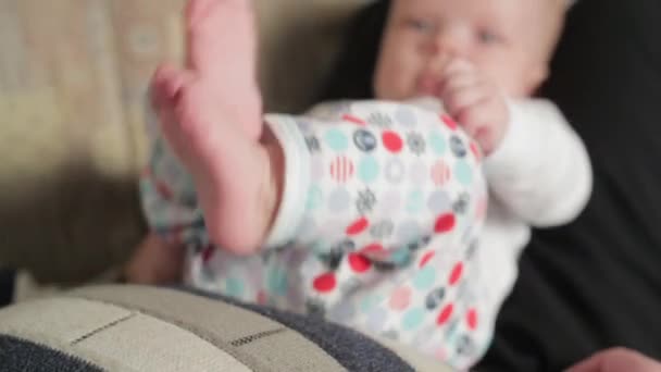 Happy babyjongen liggen op vaders schoot — Stockvideo