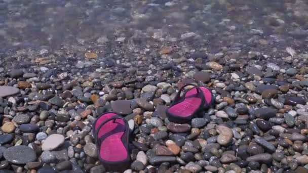 Slippers op het kiezelstrand. — Stockvideo