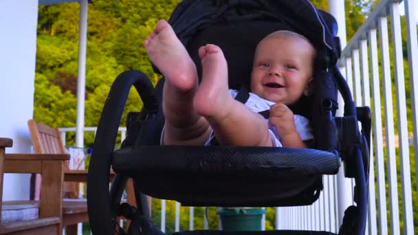 Happy baby waving his hand from the stroller — Stock Video