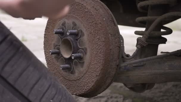 Close focus on dirty mechanics hands screwing big wheel bolts while changing flat tire on van — Stock Video