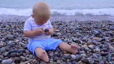 Küçük bebek taşlarla doğal çakıl plajı üzerinde çalış.