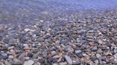 Deniz sörf. Dalgalar kıyı kayaların üzerinde çalışır. Dalgalar üzerinde çakıl kırma yakın çekim.