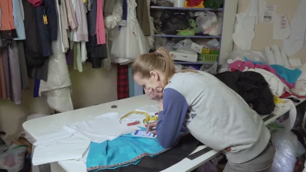 Clothing designer is working with measurements on a studio table. — Stock Video