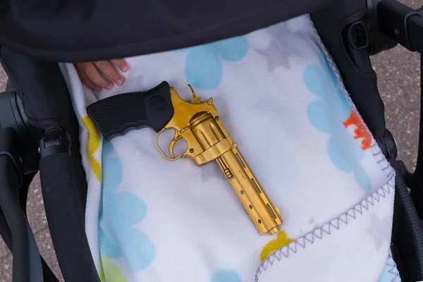 Onun elinde bir silahla uyuyan bebek