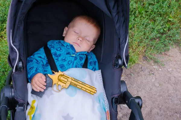 Onun elinde bir silahla uyuyan bebek