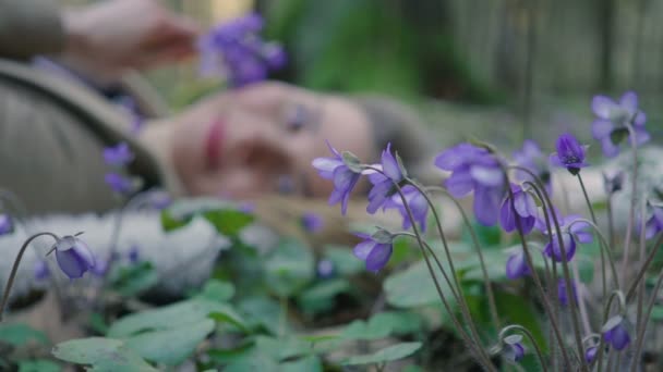 Hermosa joven acostada en el bosque flores — Vídeos de Stock