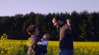 Anne, baba ve dans ve kolza tohumu alanında oynamak oğul