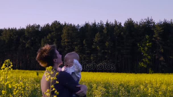 Mãe brincou com o bebê no campo de colza e dança . — Vídeo de Stock