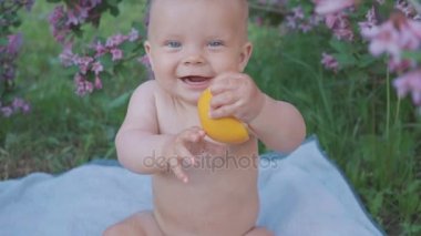 Doğada bir portakal yemek mutlu bebek .