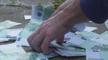 bir adam sokaktan Euro para alır