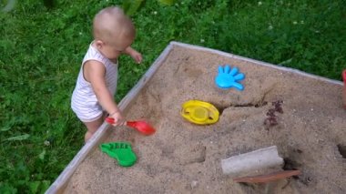 Çocuk kum havuzunda oynuyor.