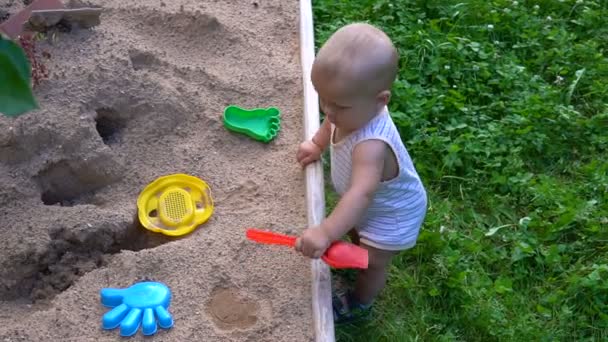 Het kind speelt in de zandbak hd — Stockvideo