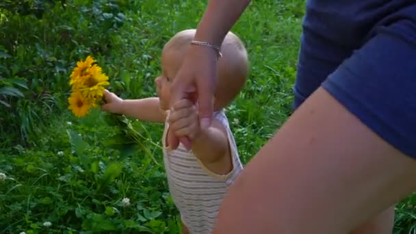 O menino está andando com flores amarelas hd — Vídeo de Stock