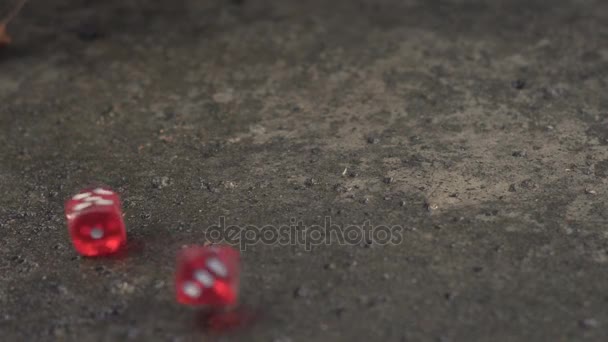 Червоні кості котиться на бетонній плиті в повільному русі — стокове відео