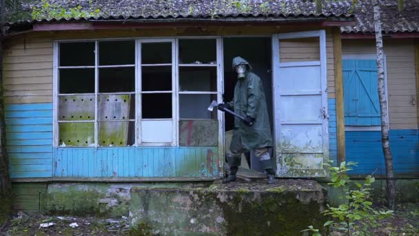 Galen stalker galning med en gasmask som vaktar ingången med en yxa. — Stockvideo